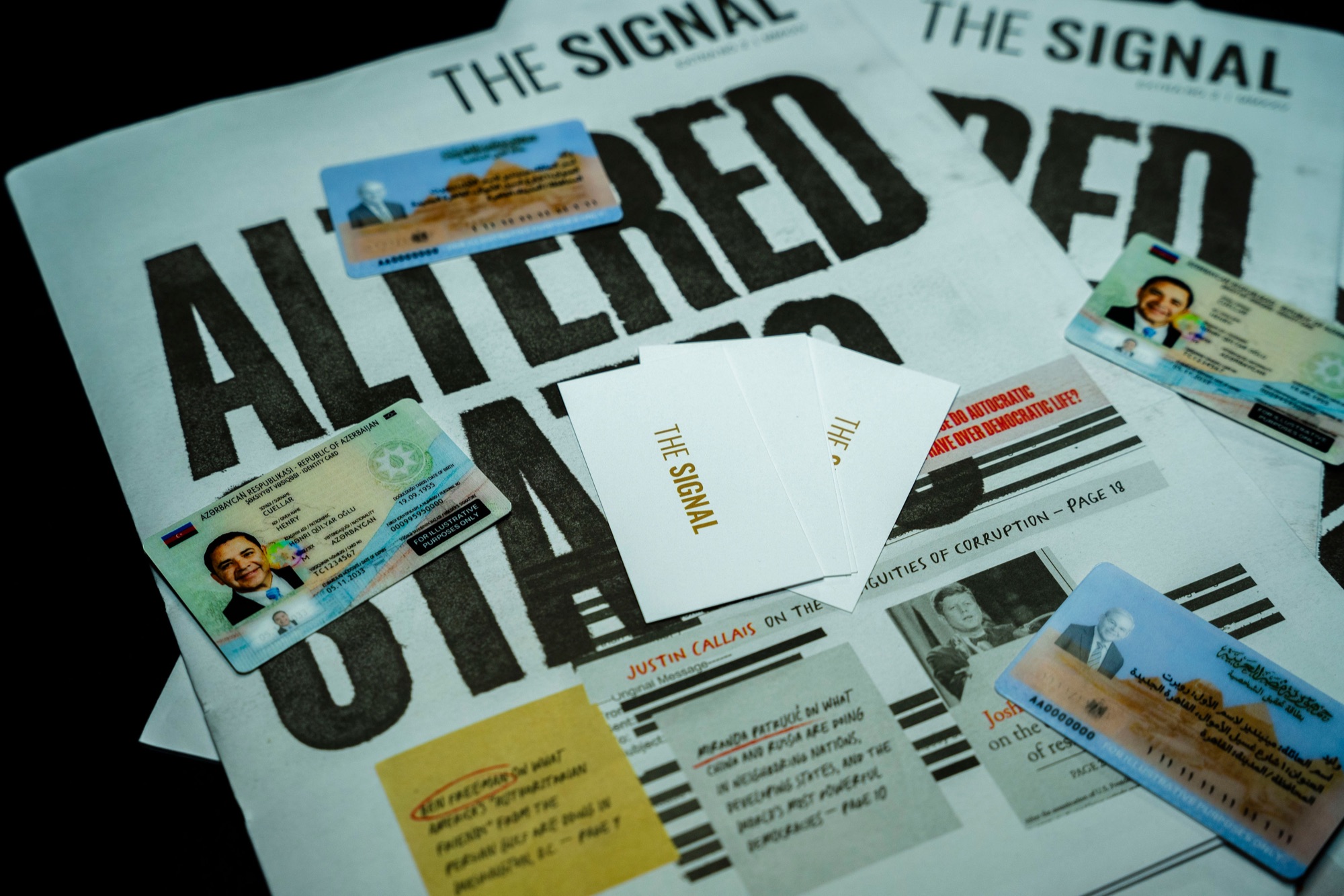 Fake senator ID cards and The Signal calling cards laid over the Altered States newspaper